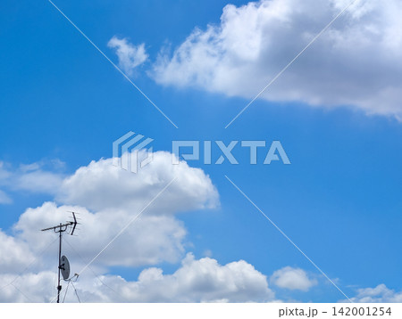 青空と白い入道雲を背景に立つテレビアンテナ / 夏の空と日常風景を表現した爽やかな背景素材 青空と白い入道雲を背景に立つテレビアンテナ / 夏の空と日常風景を表現した爽やかな背景素材 142001254