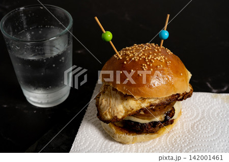 Gourmet breakfast burger with fried egg and caramelized onions on sesame brioche bun 142001461