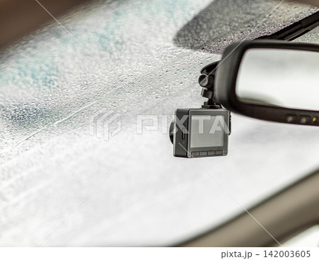Dashboard camera is mounted on the windshield of a car, with condensation on the glass creating a blurred view of the interior Dashboard camera is mounted on the windshield of a car, with condensation on the glass creating a blurred view of the interior 142003605