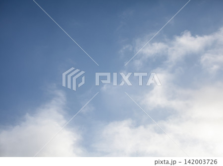 Clear blue sky features white clouds scattered throughout, creating a serene and tranquil scene during daylight hours 142003726
