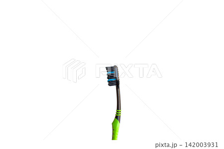 Black and green toothbrush featuring blue bristles, positioned upright against a white background, suitable for dental hygiene and oral care themes Black and green toothbrush featuring blue bristles, positioned upright against a white background, suitable for dental hygiene and oral care themes 142003931