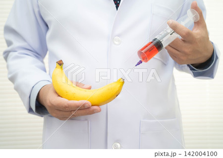 Male stands holding a banana, penis health. Male stands holding a banana, penis health. 142004100