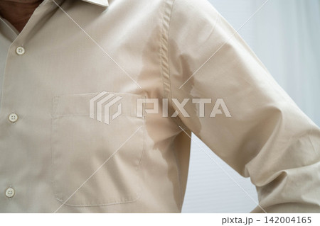 Man with sweaty arm pit on shirt when working in office, Hyperhidrosis sweating. Man with sweaty arm pit on shirt when working in office, Hyperhidrosis sweating. 142004165