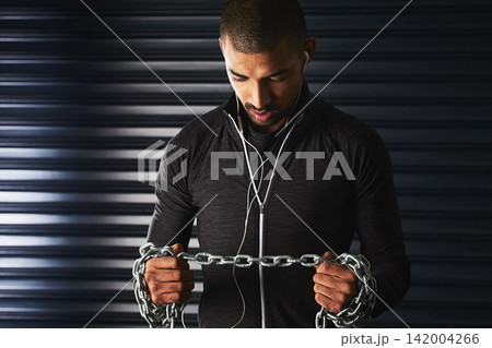 Man, metal chain and workout in gym, earphones and listen to music for motivation in exercise. Male person, power and iron rope for training or fitness, strong and athlete for muscle and audio Man, metal chain and workout in gym, earphones and listen to music for motivation in exercise. Male person, power and iron rope for training or fitness, strong and athlete for muscle and audio 142004266
