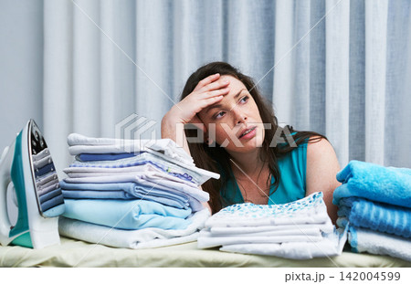 Laundry, stress headache and woman in home with mess, clothes and clutter in apartment. Spring cleaning, chaos and frustrated female person with anger, fatigue and burnout for washing crisis in house 142004599