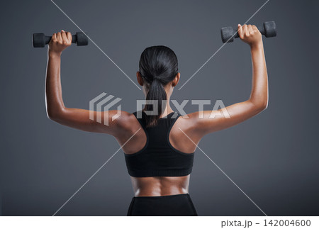 Back, fitness and woman with dumbbell in studio for muscle workout, training and healthy body. Sports, person and athlete with equipment for cardio, strength exercise and wellness on gray background Back, fitness and woman with dumbbell in studio for muscle workout, training and healthy body. Sports, person and athlete with equipment for cardio, strength exercise and wellness on gray background 142004600