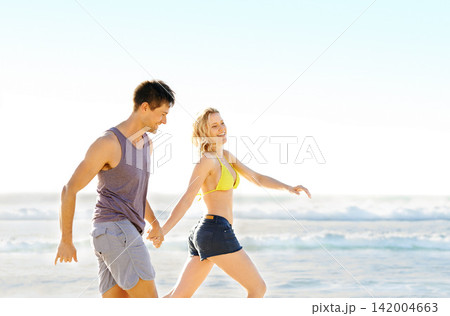 Couple, happiness and running on beach for fitness, health and exercise in nature for workout. Man, woman and holding hands in summer for love, training and holiday at beach for support and travel. Couple, happiness and running on beach for fitness, health and exercise in nature for workout. Man, woman and holding hands in summer for love, training and holiday at beach for support and travel. 142004663