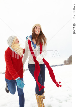 Women, friendship and snow in winter for vacation is Alaska for Christmas, festive and travel for bonding. Female people, play and laugh with hug, happiness and love for holiday, break or retreat 142004677