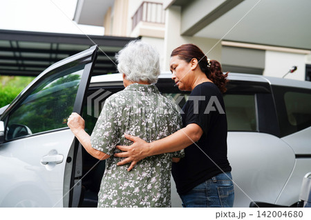 Caregiver help Asian elderly woman disability patient get in her car. Caregiver help Asian elderly woman disability patient get in her car. 142004680