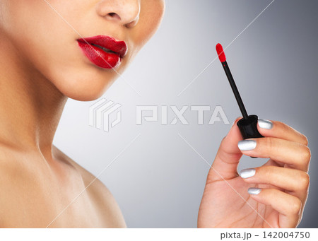 Studio, person and hand with red lipstick, lips and application of makeup, self care and product for colour. Background, aesthetic and healthy cosmetics, texture and beauty for mouth of model 142004750