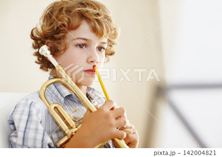 Thinking, music sheet and child with trumpet for learning, musical lesson and practice for talent show. Musician, creative hobby and excited young boy with instrument, artist and notes to play song 142004821