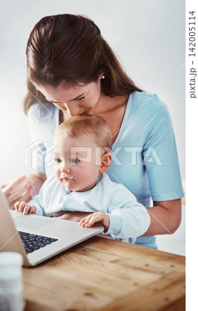 Mom, baby and desk with laptop in house for child development, video and mothers day with kiss on head. Woman, kid and table with technology in home for learning, entertainment and growth with 142005114