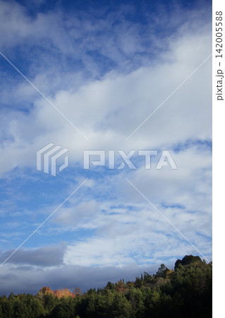 秋の山並みと、深い水色の空に漂う秋の雲 142005588