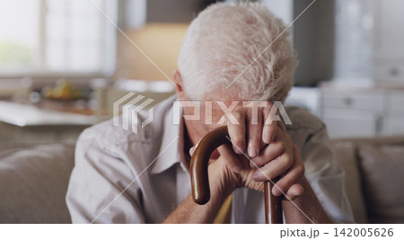 Sofa, cane and sad senior man with depression, grief or loss in living room of nursing home. Mental health, retirement and lonely person with disability, walking stick and thinking on couch in house 142005626