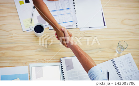 Partners, handshake and agree in meeting at desk, deal and thank you for merger at finance firm. Top view, greeting and b2b for support on budget in office, b2b and hiring or onboarding for business Partners, handshake and agree in meeting at desk, deal and thank you for merger at finance firm. Top view, greeting and b2b for support on budget in office, b2b and hiring or onboarding for business 142005706