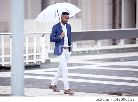 Business, man and walking and umbrella in rain, outside and financial insurance for safety or security. Assurance, accountability and protection or cover for assets, future and investment for work Business, man and walking and umbrella in rain, outside and financial insurance for safety or security. Assurance, accountability and protection or cover for assets, future and investment for work 142006518