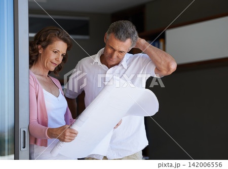 Mature couple, planning and interior design with blueprint or documents for maintenance or renovation at house. Creative man or woman with paperwork or floor layout for home improvement or startup Mature couple, planning and interior design with blueprint or documents for maintenance or renovation at house. Creative man or woman with paperwork or floor layout for home improvement or startup 142006556