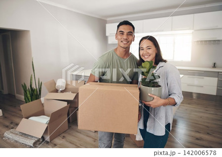 Young couple, portrait and moving to new home with boxes for renovation, investment or relocation. Happy, man and woman carrying plant for apartment interior, property rent and mortgage loan together Young couple, portrait and moving to new home with boxes for renovation, investment or relocation. Happy, man and woman carrying plant for apartment interior, property rent and mortgage loan together 142006578