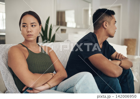 Divorce, fight or arms crossed couple on sofa for anxiety, fear or frustrated by liar, stress or drama at home. Marriage, conflict or asian people argue in living room with blame, regret or mistake 142006950