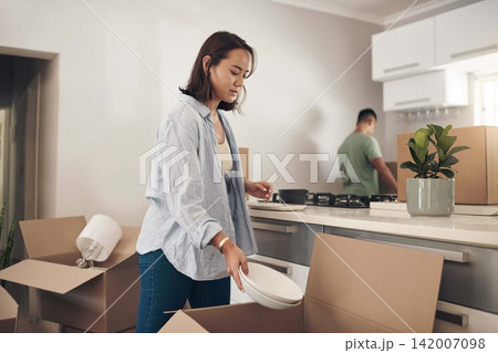 Young couple, furniture and moving to home with boxes for renovation, investment or relocation. Partners, man and woman carrying plate for apartment interior, property rent or mortgage loan together 142007098