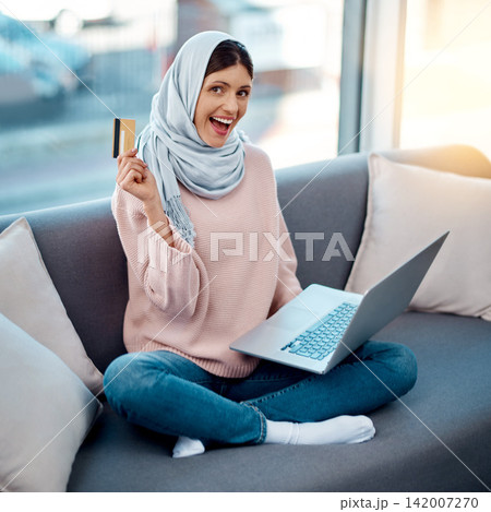Credit card, portrait or Islamic girl on laptop in home for ecommerce sale on digital fintech website. Excited, payment or Muslim woman typing financial info for online shopping or internet banking 142007270