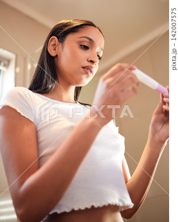 Anxiety, woman and pregnancy test in home for results, scared or news for ivf fail. Maternity, stress and serious person check stick with fear, waiting and infertility in low angle in apartment Anxiety, woman and pregnancy test in home for results, scared or news for ivf fail. Maternity, stress and serious person check stick with fear, waiting and infertility in low angle in apartment 142007575