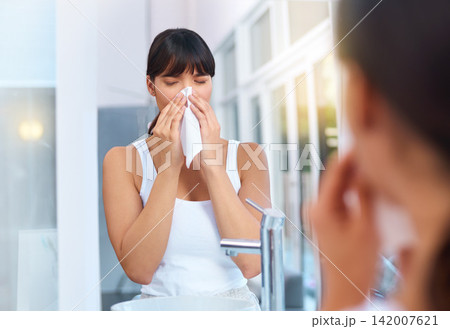 Woman, sick and allergies in bathroom for healthcare, virus and illness in morning for weather change. Asian female person, cough and tissue for sneezing, flu and reflection of medical problem. Woman, sick and allergies in bathroom for healthcare, virus and illness in morning for weather change. Asian female person, cough and tissue for sneezing, flu and reflection of medical problem. 142007621