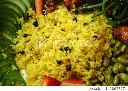 Colorful Yellow Rice Plate With Avocado Slices, Vegetables and Spiced Peppercorns for Healthy Lunch 142007727