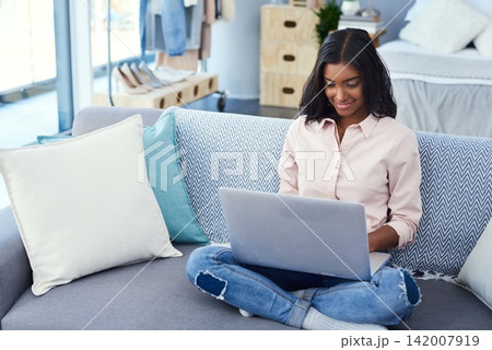 Laptop, typing and woman on sofa in home for freelance creative journalism startup business. Technology, research and Indian female writer work on online project with computer in living room at house Laptop, typing and woman on sofa in home for freelance creative journalism startup business. Technology, research and Indian female writer work on online project with computer in living room at house 142007919
