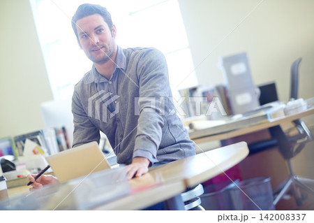 Man, tablet and graphic designer with desk for creative career, lens flare and startup business. Online work, morning and male teacher in staff room with school, technology and education for children 142008337