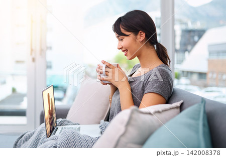Laptop, coffee or girl streaming movie to relax in living room for online subscription, film or video. Drinking tea, smile or happy woman watching series on sofa for entertainment, comedy or break Laptop, coffee or girl streaming movie to relax in living room for online subscription, film or video. Drinking tea, smile or happy woman watching series on sofa for entertainment, comedy or break 142008378