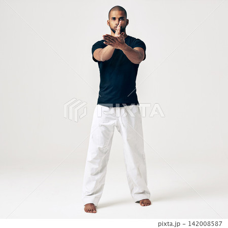Studio, portrait and man with karate for practice, training exercise and self defence in workout. Serious, male person and pose in martial arts for sports, fitness and health on white background Studio, portrait and man with karate for practice, training exercise and self defence in workout. Serious, male person and pose in martial arts for sports, fitness and health on white background 142008587