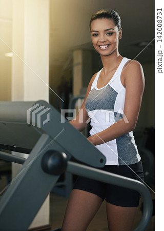 Black woman, gym and treadmill with smile for workout to exercise and fitness routine for health. Female person, happy and training with commitment for wellness, wellbeing and self care in portrait Black woman, gym and treadmill with smile for workout to exercise and fitness routine for health. Female person, happy and training with commitment for wellness, wellbeing and self care in portrait 142008731