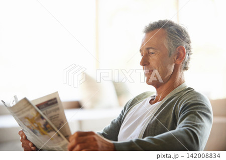 Mature, man and newspaper for reading in home, relax and information or articles in morning with coffee. News, breakfast table and rest and calm for entertainment pages, current events in apartment Mature, man and newspaper for reading in home, relax and information or articles in morning with coffee. News, breakfast table and rest and calm for entertainment pages, current events in apartment 142008834