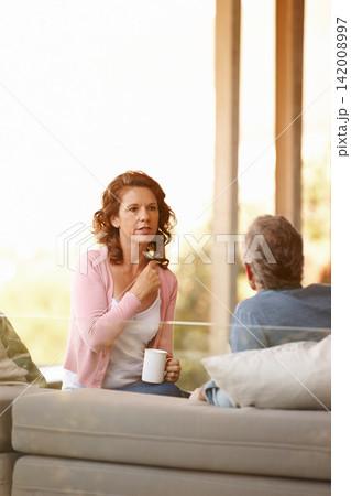Mature couple, conversation and bonding with tea on a cabin porch, relationship and trust for discussion. Communication, comfortable and relax, support and marriage over coffee at home by nature 142008997