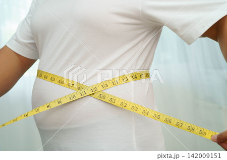 Asian woman with fat belly big size overweight and obesity with measure tape. 142009151