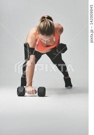 Push up, arms and woman with weights in studio for health, wellness and body training. Fitness, energy and female athlete with equipment for sports workout or exercise isolated by gray background. Push up, arms and woman with weights in studio for health, wellness and body training. Fitness, energy and female athlete with equipment for sports workout or exercise isolated by gray background. 142009845