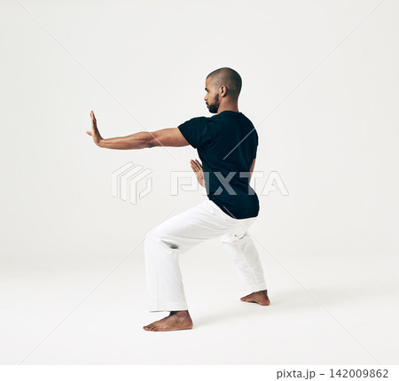 Man, studio and martial arts for defense practice, action and karate exercise on white background. Black male person, mockup space and training for combat, fight and position of attack in taekwondo Man, studio and martial arts for defense practice, action and karate exercise on white background. Black male person, mockup space and training for combat, fight and position of attack in taekwondo 142009862