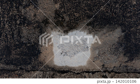 Weathered cement surface showing a distinct contrast between dry patches and wet areas. Mold grows in damp areas. Result of a long period of time since the construction of the floor was completed. 142010106