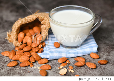 Almond milk and Almonds nuts on on sack background, Delicious sweet almonds on the table, roasted almond nut for healthy food and snack 142010634