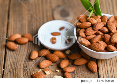 Almond milk and Almonds nuts on on white bowl background, Delicious sweet almonds on the table, roasted almond nut for healthy food and snack Almond milk and Almonds nuts on on white bowl background, Delicious sweet almonds on the table, roasted almond nut for healthy food and snack 142010636