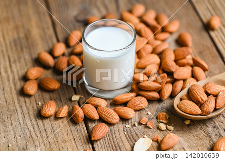 Almond milk and Almonds nuts wooden background, Delicious sweet almonds on table, roasted almond nut for healthy food and snack Almond milk and Almonds nuts wooden background, Delicious sweet almonds on table, roasted almond nut for healthy food and snack 142010639