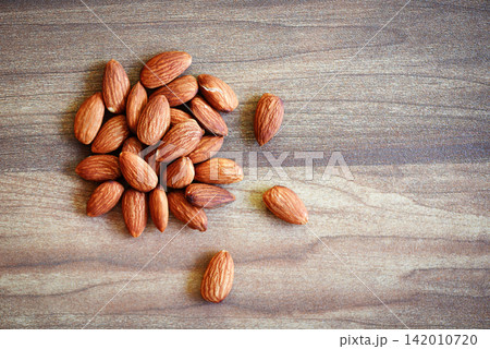 Almonds on rustic wooden background top view - Close up almond nuts natural protein food and for snack Almonds on rustic wooden background top view - Close up almond nuts natural protein food and for snack 142010720