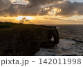 暮れ時の万座毛の断崖絶壁に差し込む夕日と海（沖縄・恩納村） 142011998