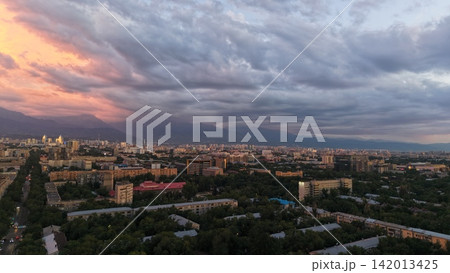 Panoramic view of cityscape with mountains and sunset sky in Almaty Panoramic view of cityscape with mountains and sunset sky in Almaty 142013425