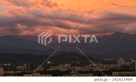 Sunset over city skyline with mountains and telecommunications tower 142013464