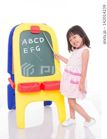 Little girl playing teacher pointing at a chalkboard with a stick, role play and leadership concept. 142014239