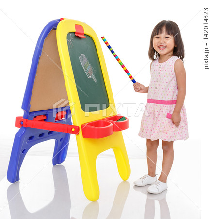 Little girl playing teacher pointing at a chalkboard with a colorful stick, role play and leadership concept. Little girl playing teacher pointing at a chalkboard with a colorful stick, role play and leadership concept. 142014323