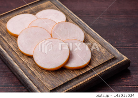Slices of boiled chicken or pork sausage as an ingredient for home cooking. Sliced boiled sausage 142015034