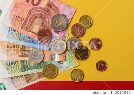 Spain, Spanish euro cash and cent coins against the background of the flag. Euro cash Spain, Spanish euro cash and cent coins against the background of the flag. Euro cash 142015039